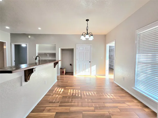 a view of a kitchen with kitchen island a counter top space appliances and cabinets