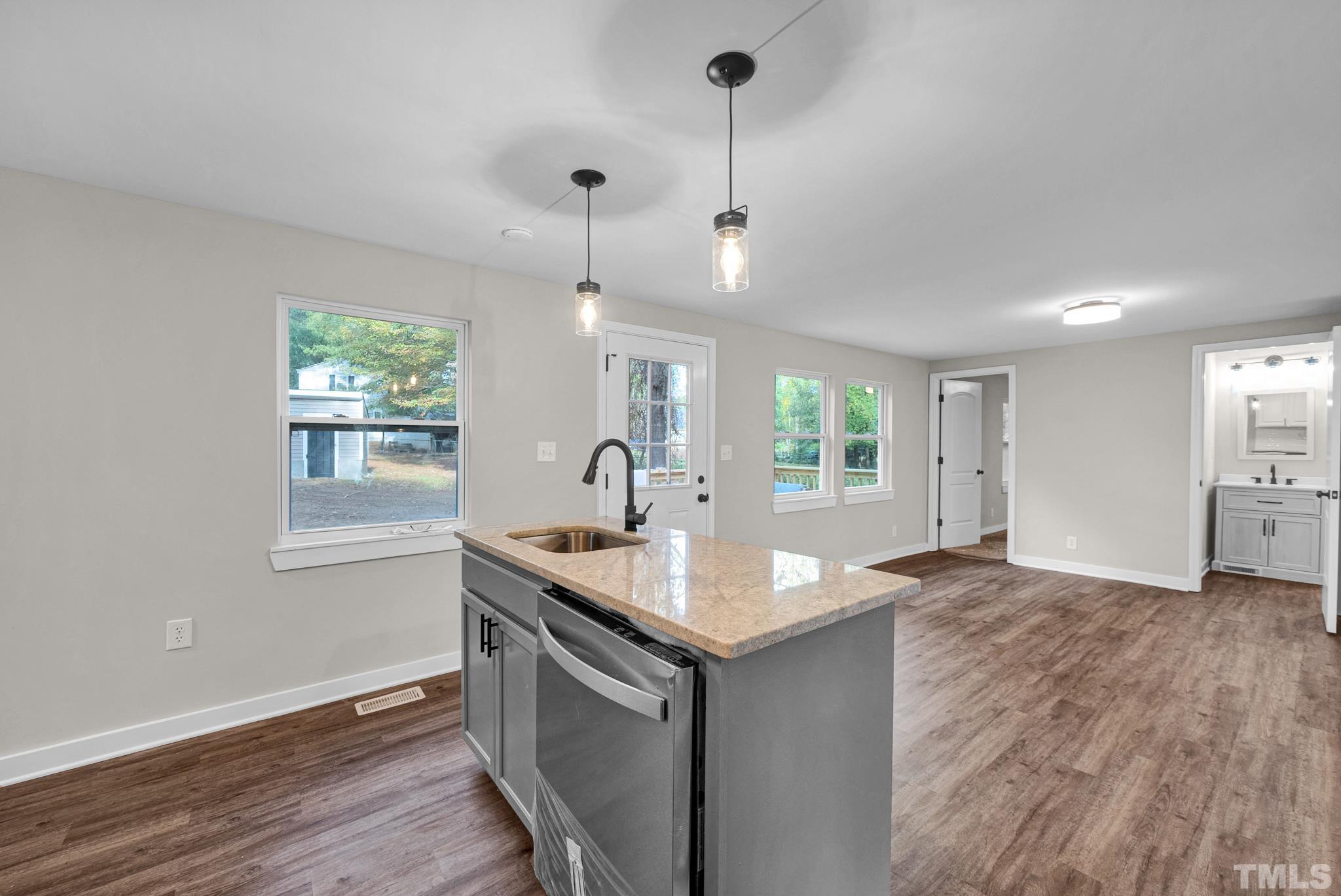 10844 Old Stage Road Raleigh, NC 27603 - Photo 7 of 17 a kitchen with granite countertop a sink stove and wooden floor