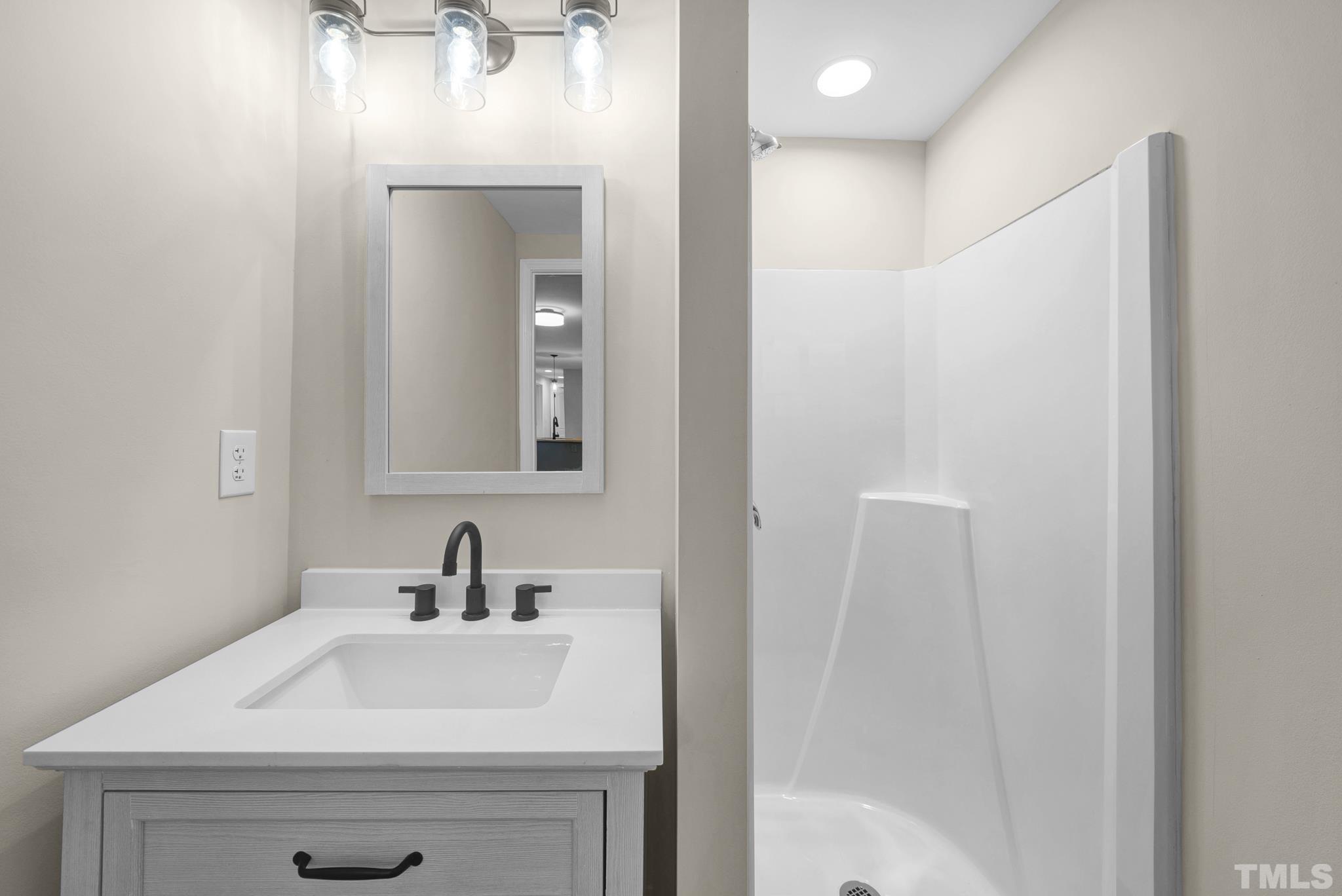 10844 Old Stage Road Raleigh, NC 27603 - Photo 10 of 17 a bathroom with a sink a mirror and vanity