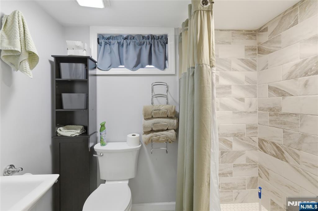 34 William Street Wallington, NJ 07057 - Photo 24 of 26 a bathroom with a toilet a sink and shower curtain