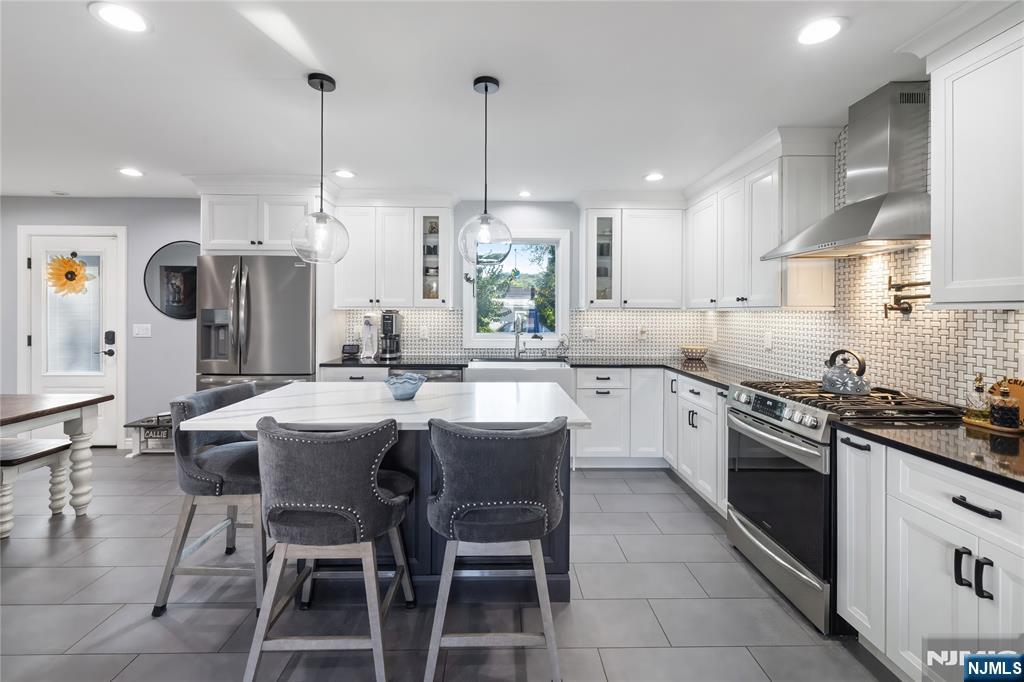 34 William Street Wallington, NJ 07057 - Photo 5 of 26 a kitchen with stainless steel appliances granite countertop a sink a stove a refrigerator a dining table and chairs
