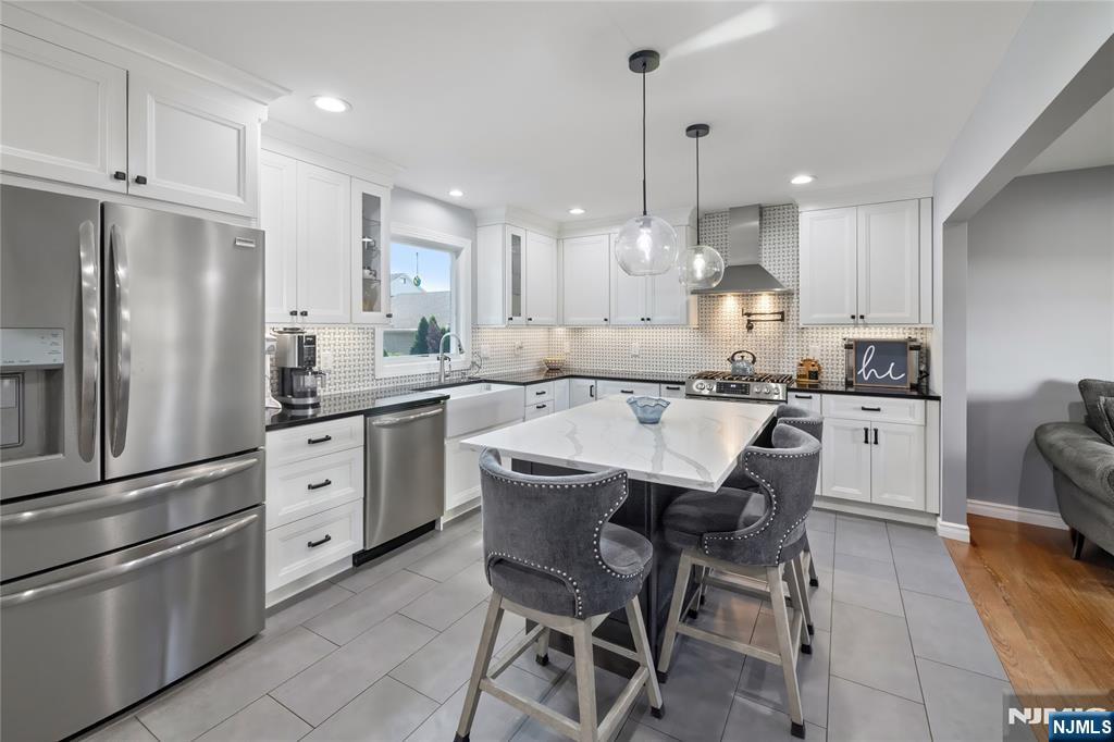 34 William Street Wallington, NJ 07057 - Photo 7 of 26 a kitchen with stainless steel appliances kitchen island granite countertop a sink a stove a refrigerator and island with wooden floor