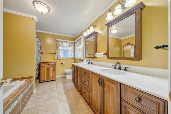 a large bathroom with a double vanity sink a mirror and a bathtub