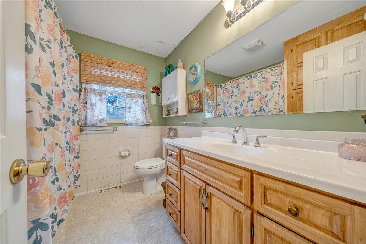 9009 Poor Mountain Road Bent Mountain, VA 24059 - Photo 19 of 30 a bathroom with a granite countertop sink mirror vanity and toilet