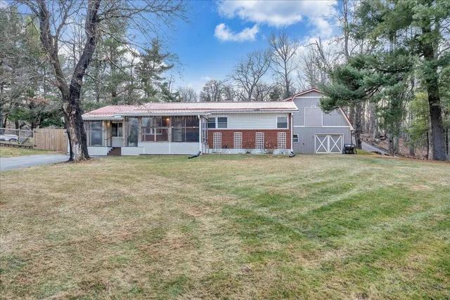 a view of a house with a big yard and large trees
