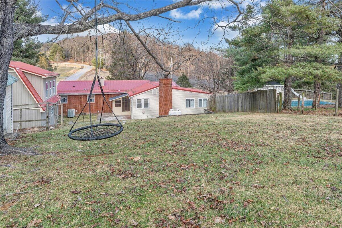 9009 Poor Mountain Road Bent Mountain, VA 24059 - Photo 28 of 30 a view of a backyard with table and chairs under an umbrella