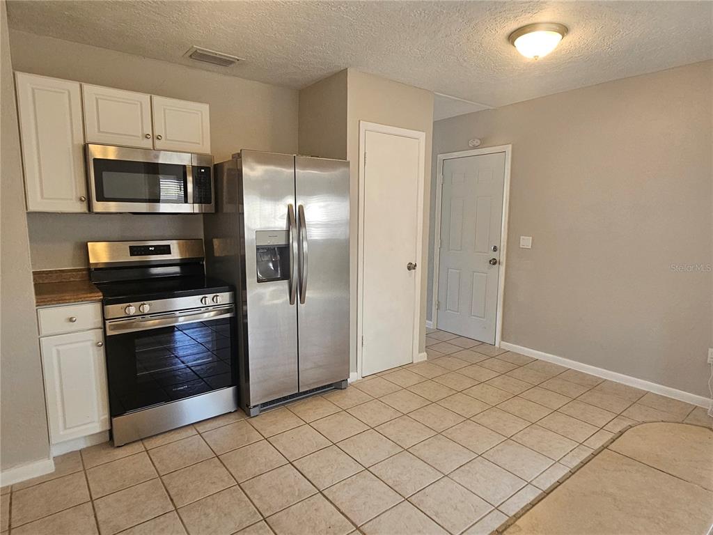 7000 Brentford Road Sarasota, FL 34241 - Photo 15 of 29 a kitchen with granite countertop a refrigerator and a stove top oven