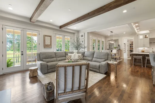 a living room with furniture a wooden floor and a large window