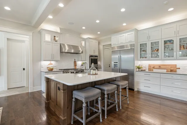 a kitchen with kitchen island granite countertop a sink and refrigerator