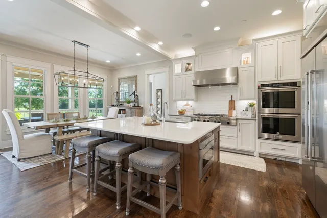 a kitchen with a table chairs microwave and cabinets