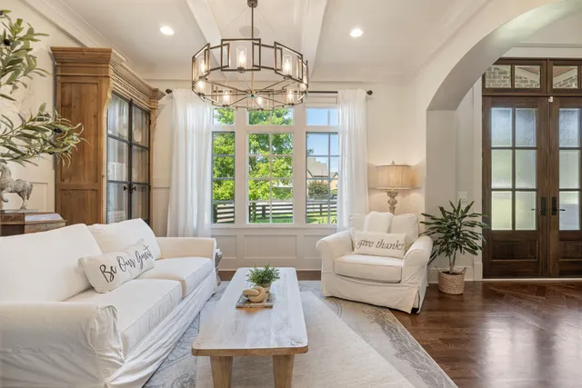 a living room with furniture and a chandelier