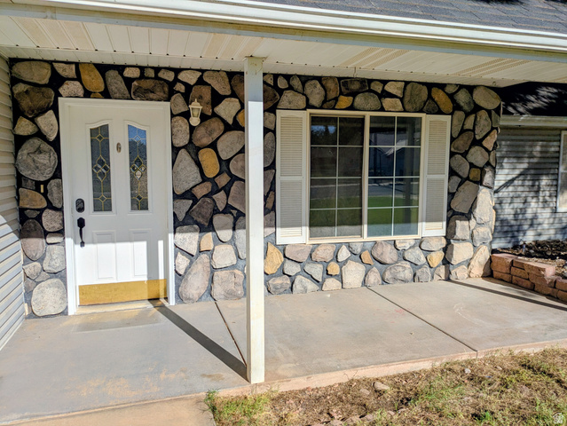 441 Main Street Hurricane, UT 84737 - Photo 4 of 29 Stone facade exterior with an inviting entry door, decorative glass inserts, and an overhead light fixture