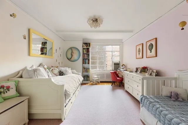 a spacious bedroom with a bed large window with table and chair