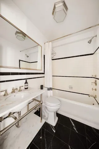 a bathroom with a double vanity sink a mirror a shower and a bathtub