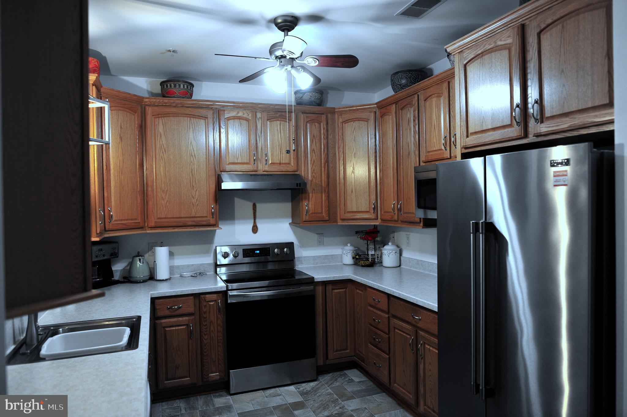 4000 Village Way, Unit 202 Boothwyn, PA 19061 - Photo 9 of 15 a kitchen with granite countertop stainless steel appliances and wooden cabinets