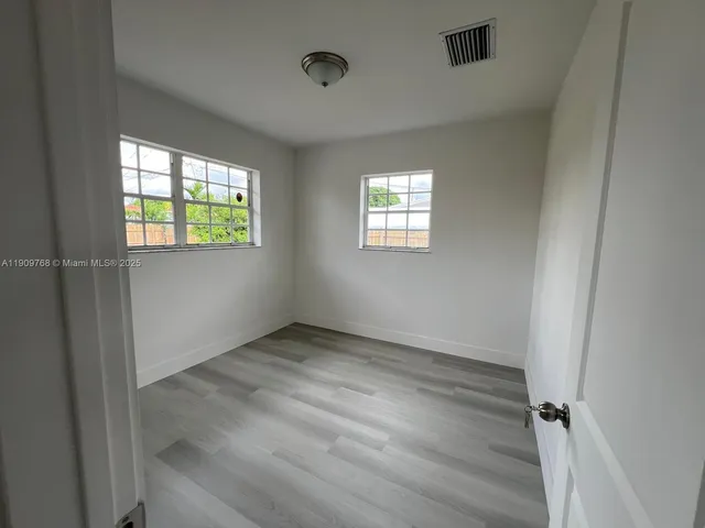 a view of wooden floor and windows in a room