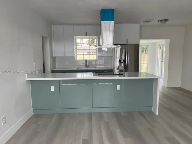 a kitchen with granite countertop a sink cabinets and stainless steel appliances