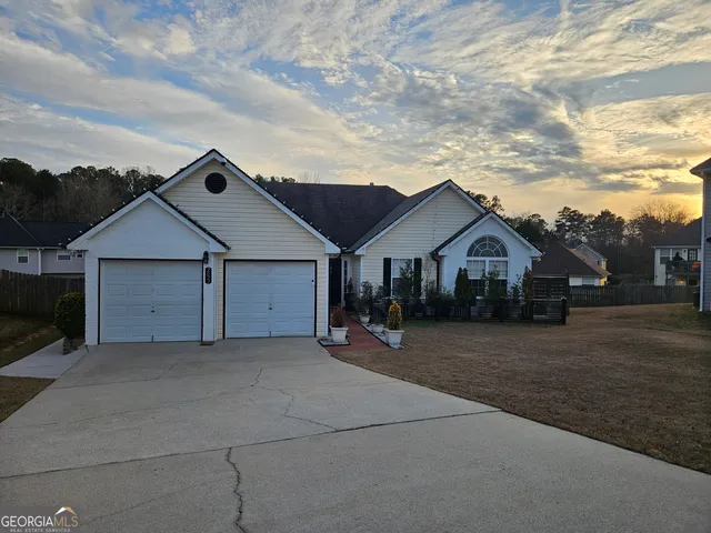 a kitchen with stainless steel appliances granite countertop a sink a stove a refrigerator cabinets and a dining table
