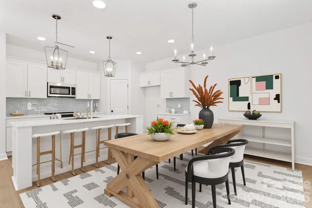 a kitchen with kitchen island a dining table chairs sink and stove
