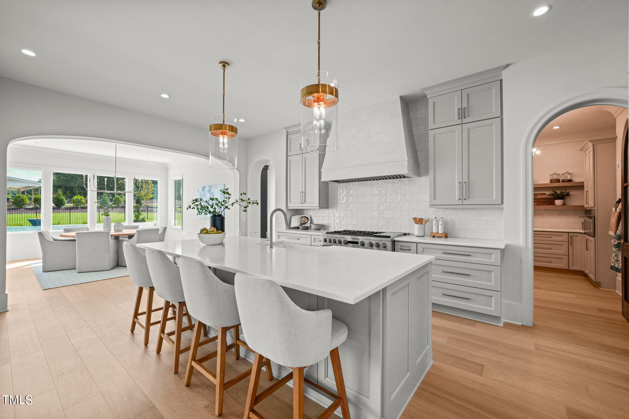 8916 Grand Highland Way Wake Forest, NC 27587 - Photo 14 of 80 a kitchen with kitchen island a stove a table and chairs in it