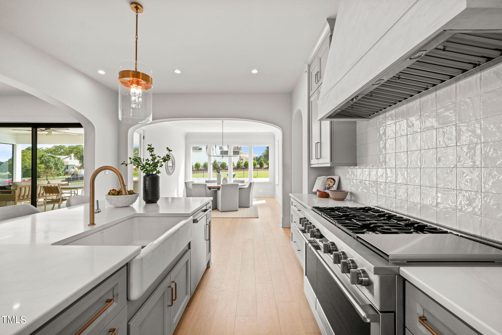 8916 Grand Highland Way Wake Forest, NC 27587 - Photo 15 of 80 a kitchen with stainless steel appliances a sink a stove top oven a counter space and cabinets