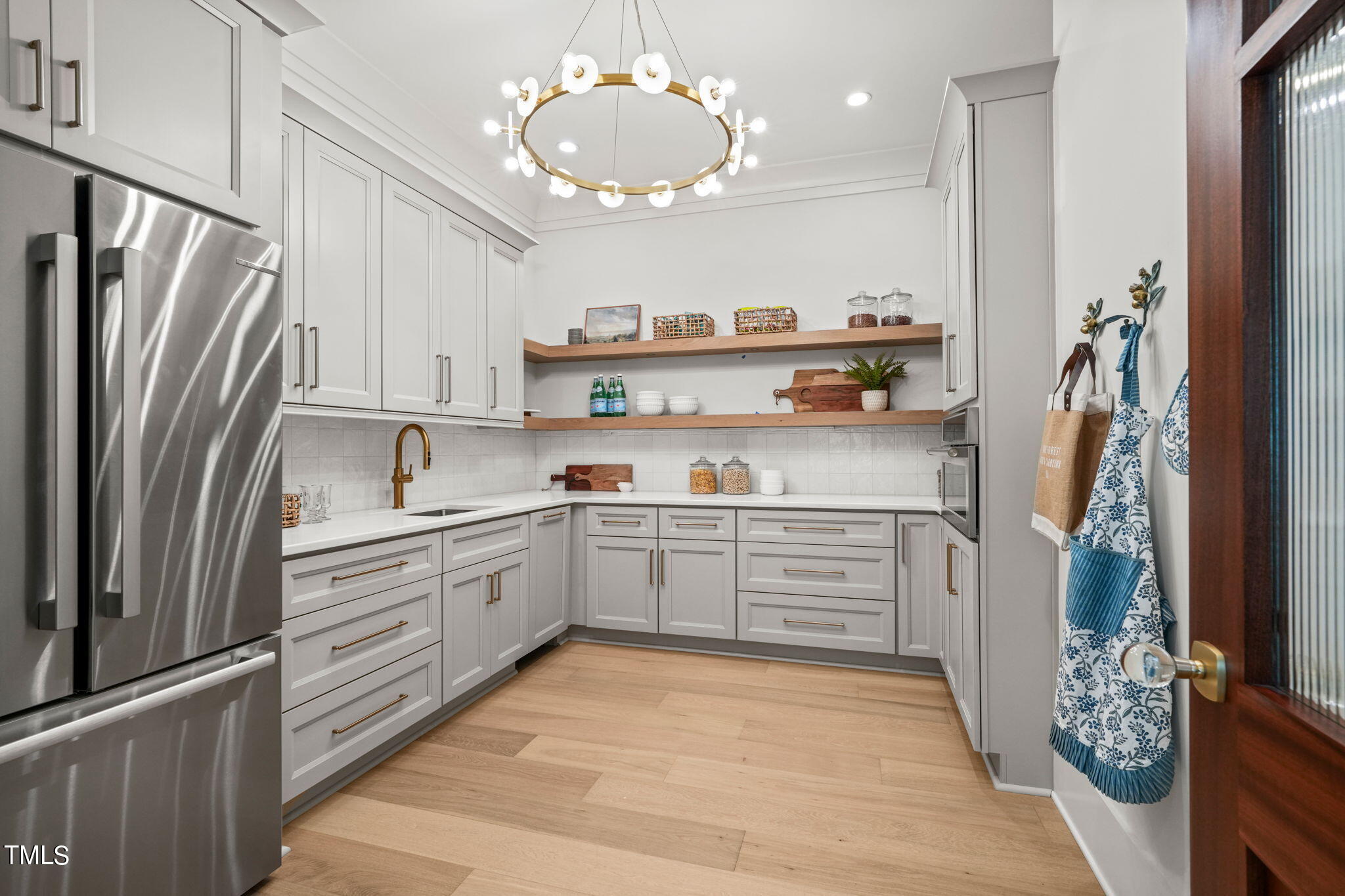 8916 Grand Highland Way Wake Forest, NC 27587 - Photo 19 of 80 a kitchen with stainless steel appliances a refrigerator sink and cabinets