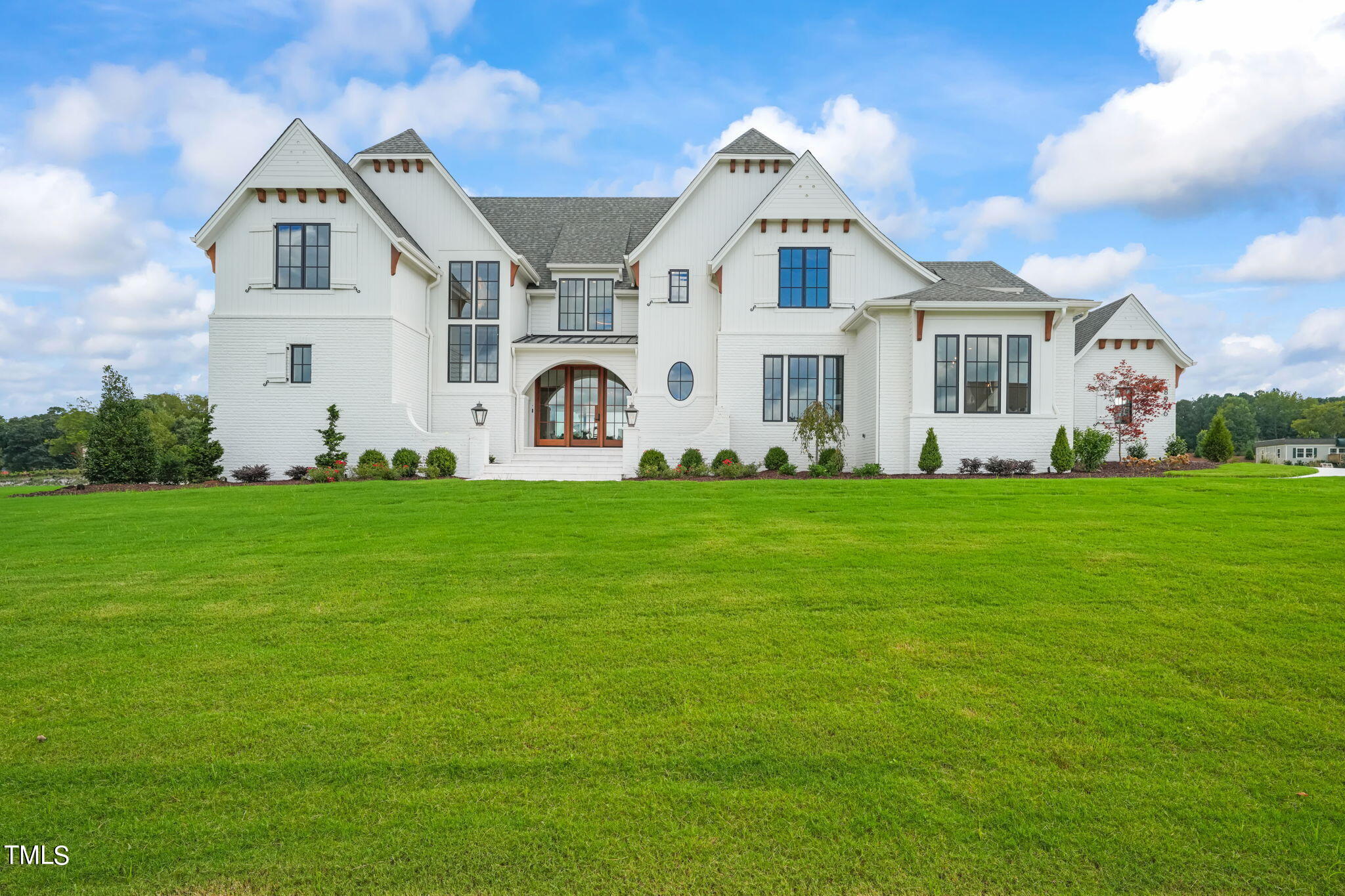 8916 Grand Highland Way Wake Forest, NC 27587 - Photo 8 of 80 a front view of a white house with a yard and trees