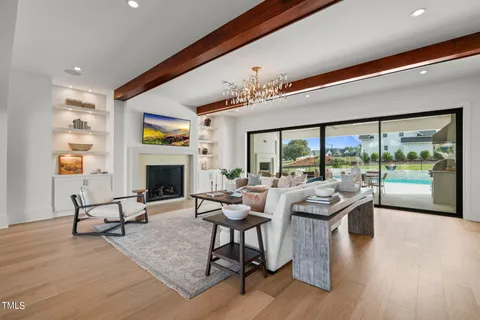 a living room with furniture a chandelier and a fireplace