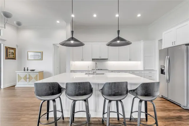 a kitchen with stainless steel appliances granite countertop a sink a stove and a refrigerator