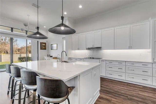 a large kitchen with stainless steel appliances lots of counter space and wooden floor