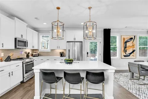 a view of kitchen with granite countertop cabinets table and chairs