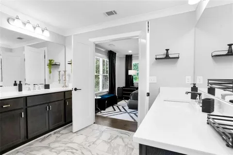 a large white room with mirror and view of bathroom