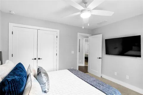 a spacious bedroom with a bed and a flat screen tv