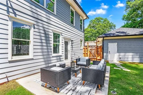 a view of house with backyard and sitting area