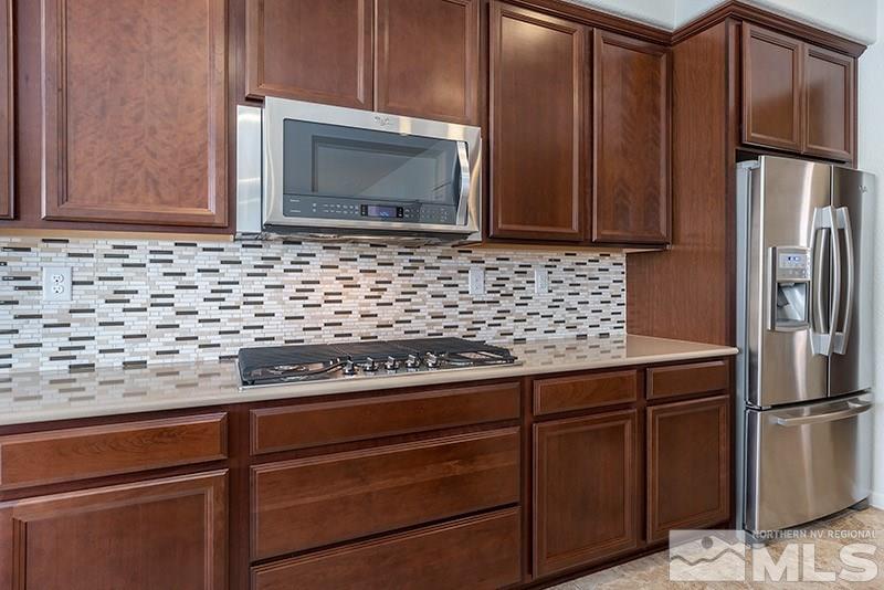 9285 Sassafras Trail Reno, NV 89523 - Photo 25 of 28 a kitchen with granite countertop stainless steel appliances a stove microwave and refrigerator