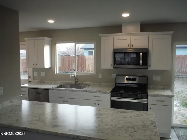 a large kitchen with granite countertop a stove and a sink