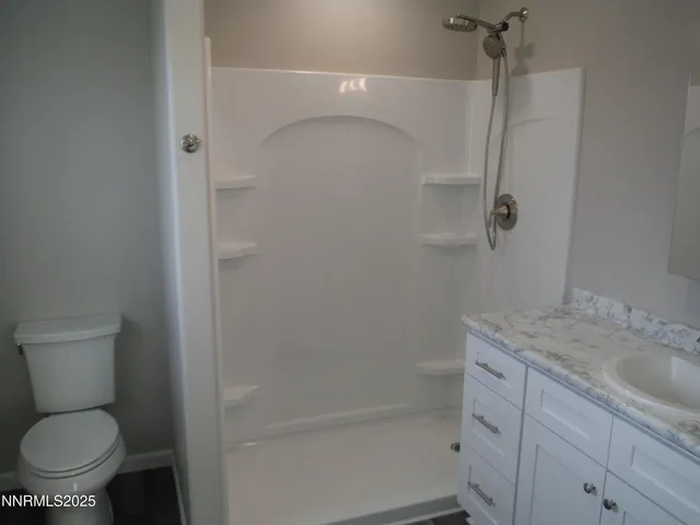 a bathroom with a granite countertop toilet and a sink