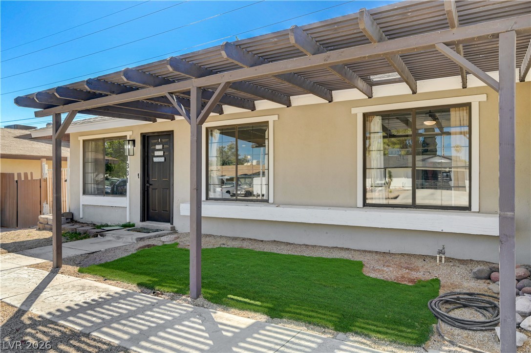 1331 Pinto Road Boulder City, NV 89005 - Photo 10 of 46 A welcoming front entrance featuring a stylish wooden pergola and a combination of natural and artificial greenery.