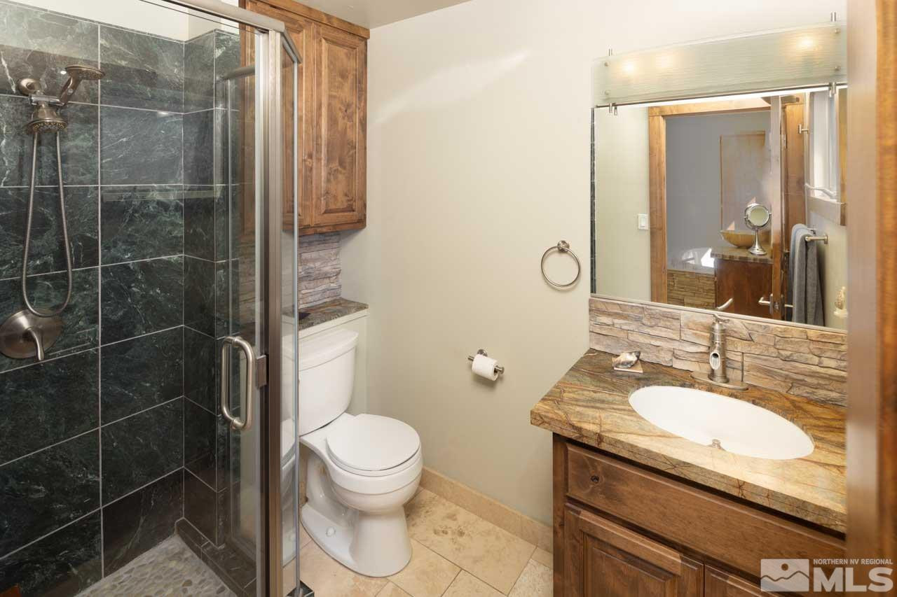 633 Riven Rock Road Zephyr Cove, NV 89448 - Photo 22 of 41 a bathroom with a granite countertop sink a toilet and shower