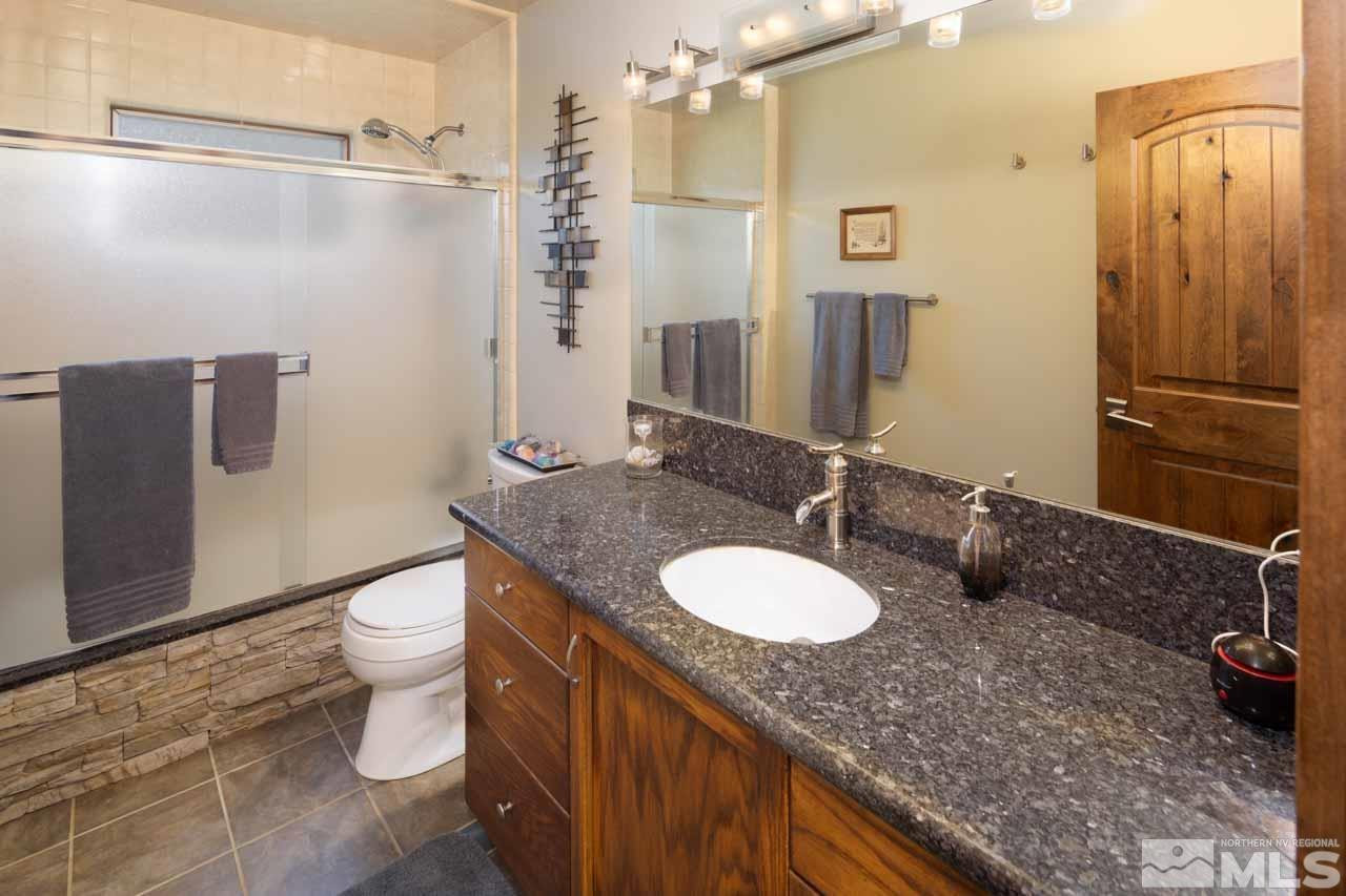 633 Riven Rock Road Zephyr Cove, NV 89448 - Photo 24 of 41 a bathroom with a granite countertop sink toilet and shower