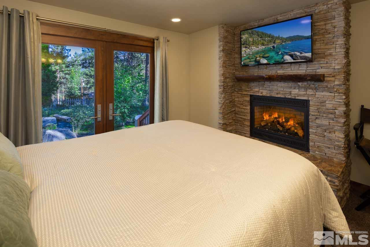 633 Riven Rock Road Zephyr Cove, NV 89448 - Photo 6 of 41 a large white bed with a fireplace in it