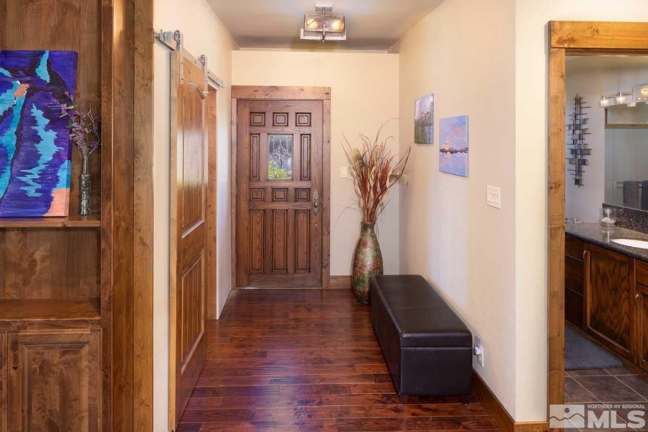 633 Riven Rock Road Zephyr Cove, NV 89448 - Photo 7 of 41 a view of a hallway with wooden floor and a living room