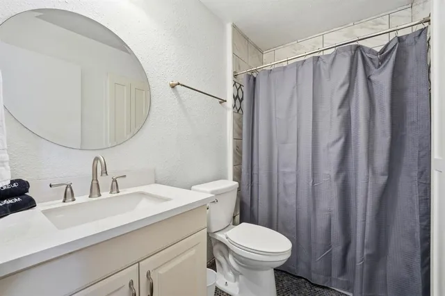 a bathroom with a sink a toilet and shower curtain