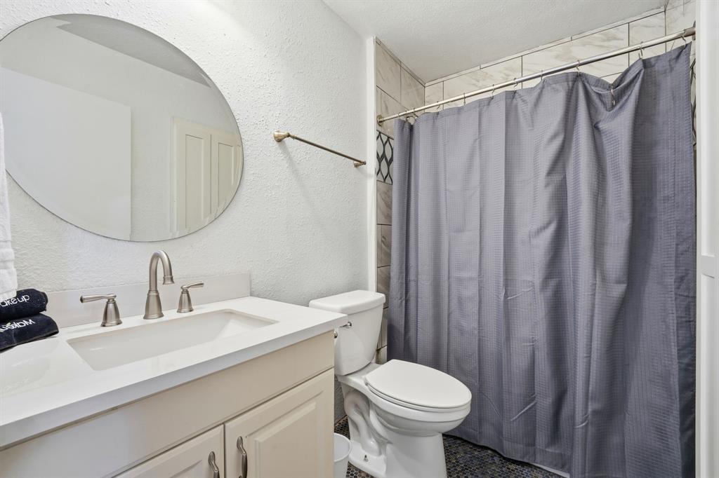 802 Buckingham Place Austin, TX 78745 - Photo 18 of 21 a bathroom with a sink a toilet and shower curtain