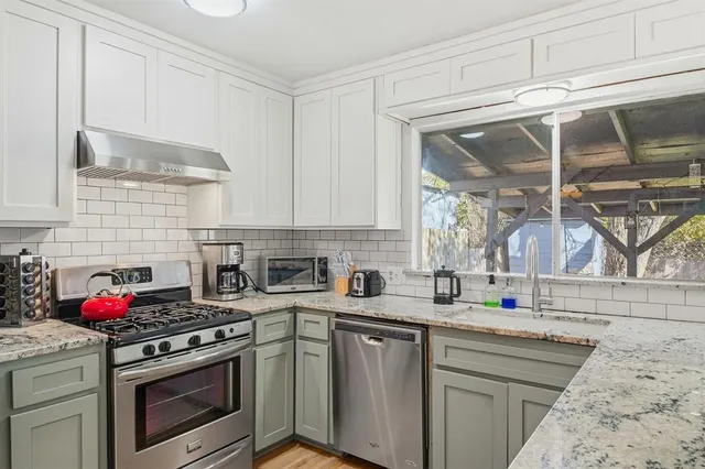 a kitchen with stainless steel appliances granite countertop a stove and a sink