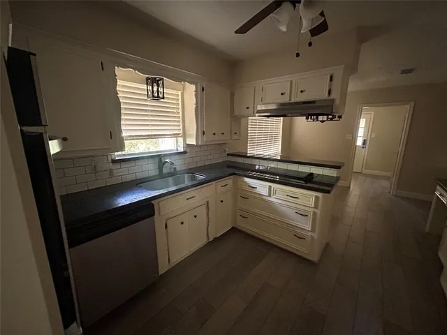 a kitchen with granite countertop white cabinets and appliances