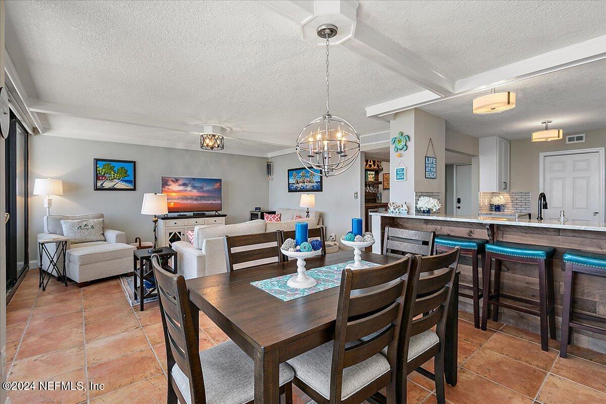 1301 1st Street South, Unit 1505 Jacksonville Beach, FL 32250 - Photo 36 of 36 a view of a dining room and livingroom furniture and chandelier