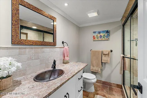 a bedroom with a bed and a lamp on a dresser