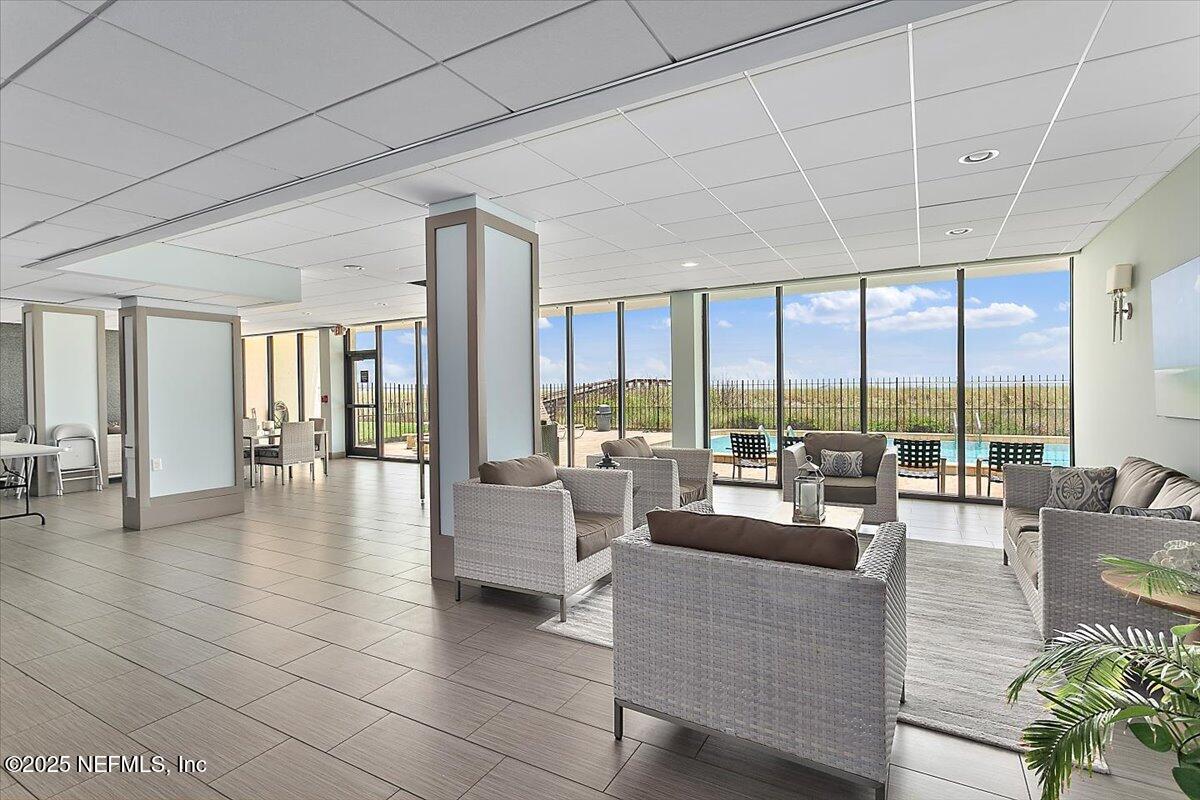 1301 1st Street South, Unit 1505 Jacksonville Beach, FL 32250 - Photo 29 of 36 a living room with furniture and floor to ceiling windows