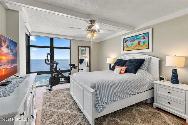 a bedroom with a bed and a lamp on a dresser